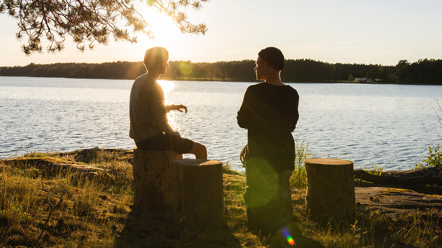 two people talking by a lake